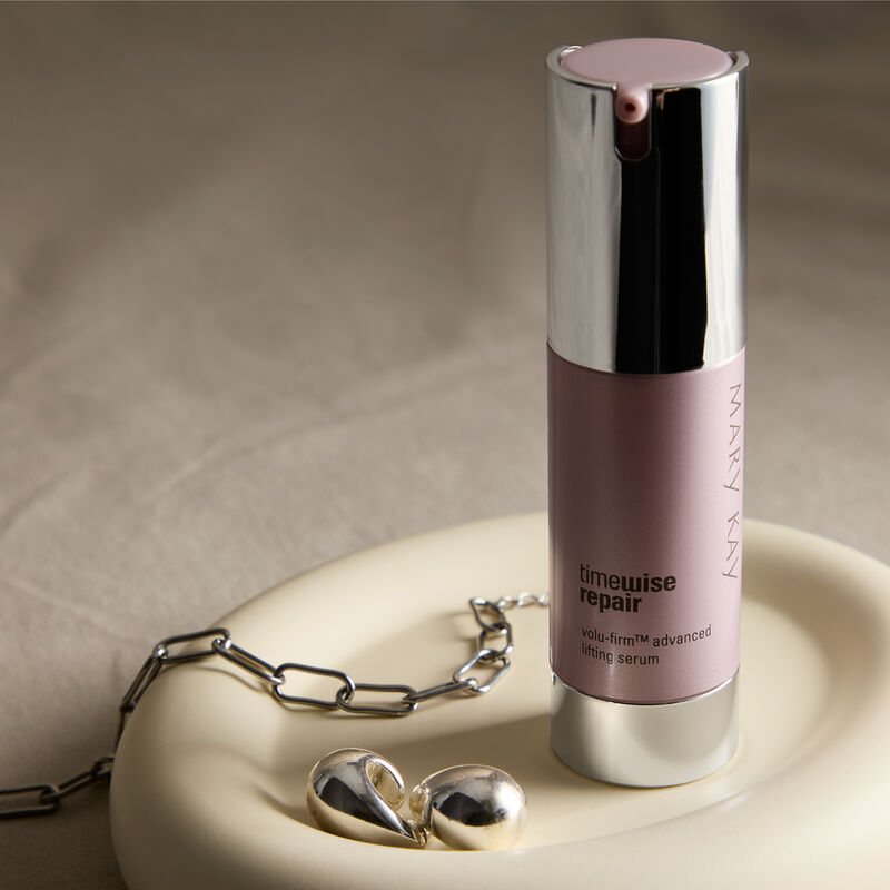 Advanced Lifting Serum sitting in a dish with a silver bracelet and earrings