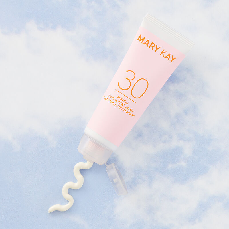 Bottle of Mary Kay Mineral Facial Sunscreen Broad Spectrum SPF 30* against blue sky with wispy white clouds