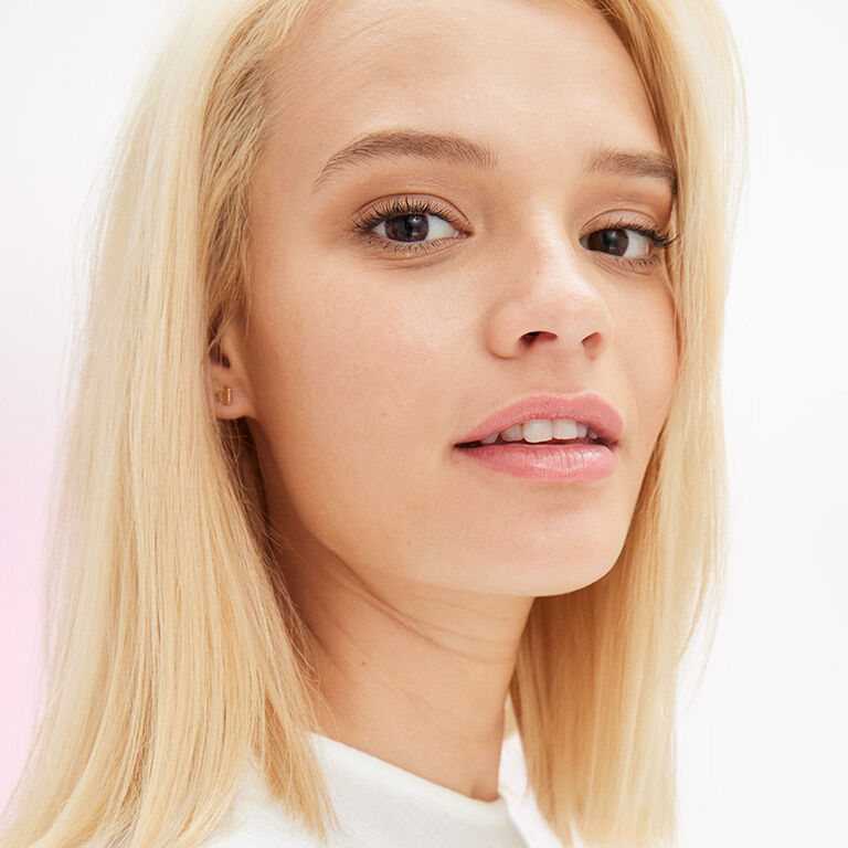 Mujer rubia de tono de piel medio con maquillaje natural.