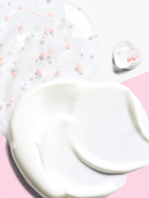 Una peque&ntilde;a cantidad de la Crema Facial para el D&iacute;a Efecto Reparador Volu-Firm&trade; FPS 30 y de la Crema Facial Nocturna Efecto Reparador con Retinol Volu-Firm&reg; TimeWise Repair&reg;, sobre un fondo rosa y blanco, listas para cuidar tu piel d&iacute;a y noche.