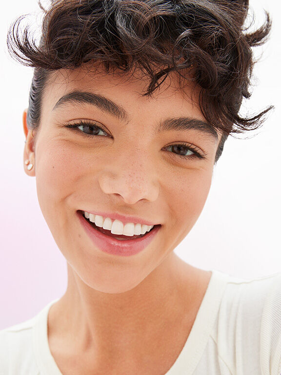 Una mujer morena de tono de piel medio con maquillaje natural.
