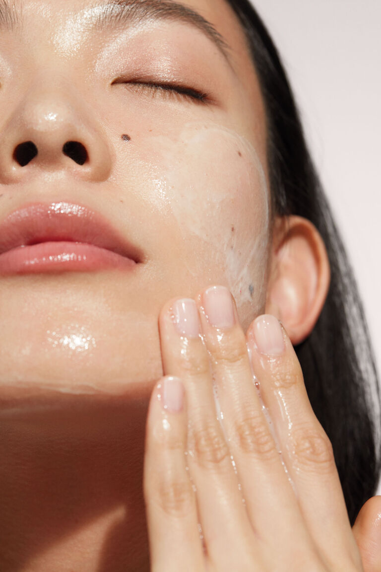 Primer plano de una mujer aplicando el Limpiador Facial 4 en 1 TimeWise&reg; de Mary Kay&reg;