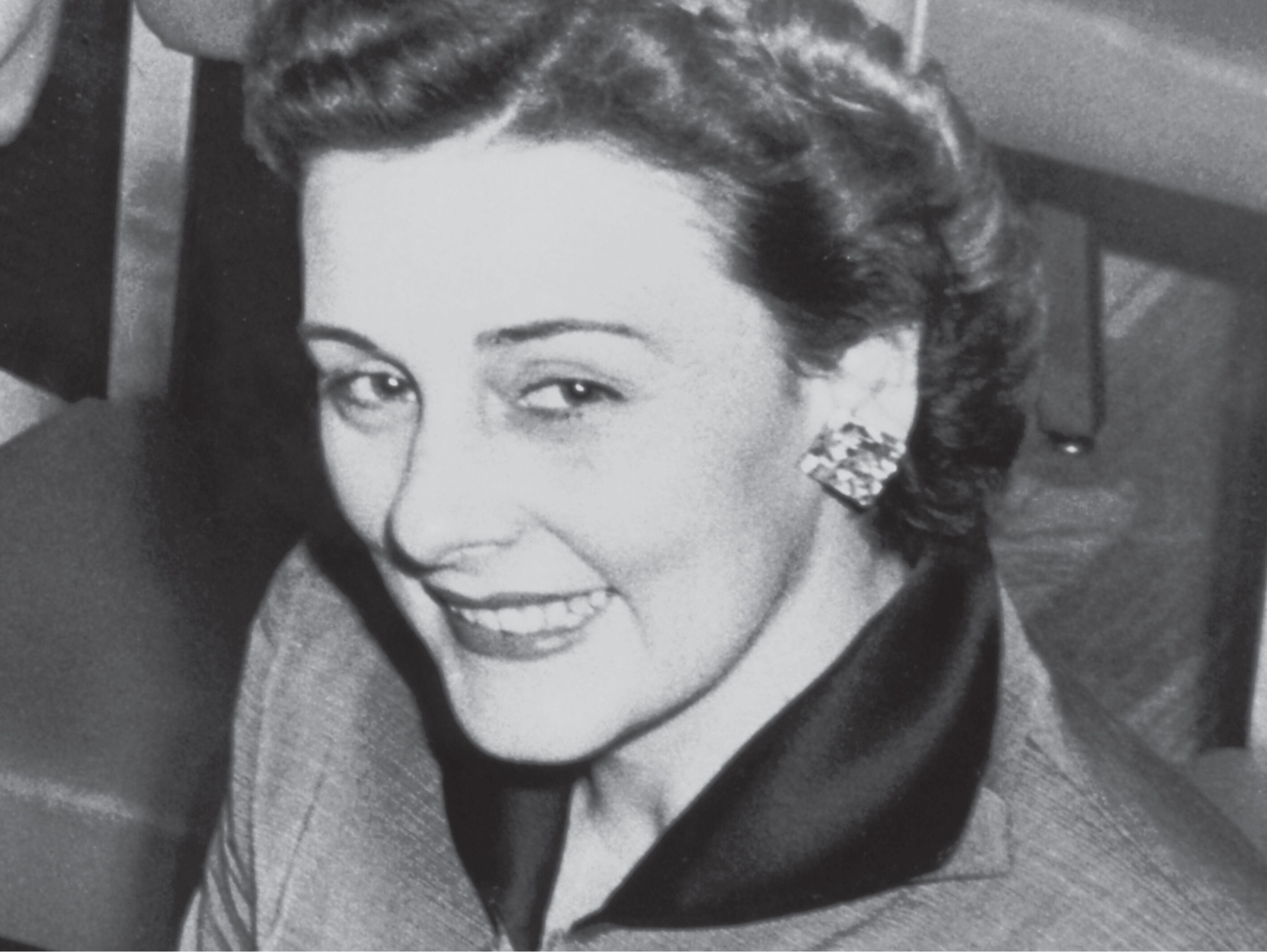 Fotograf&iacute;a vintage de la fundadora de Mary Kay, luciendo un traje elegante y aretes llamativos.