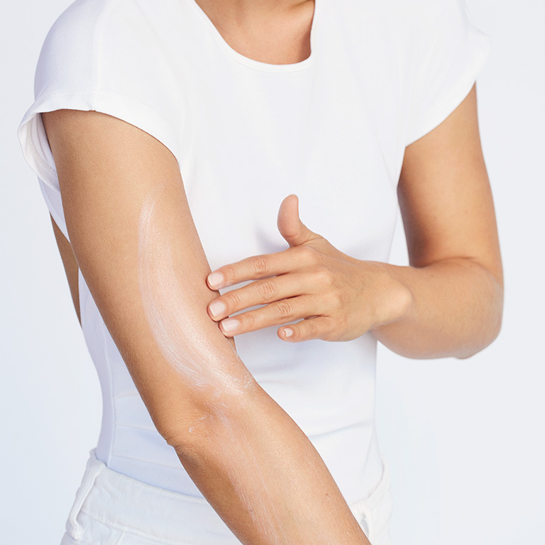 Modelo de tono de piel medio aplicando Protector Solar FPS 50+ Mary Kay&reg; Protecci&oacute;n Muy Alta en la parte superior del brazo.