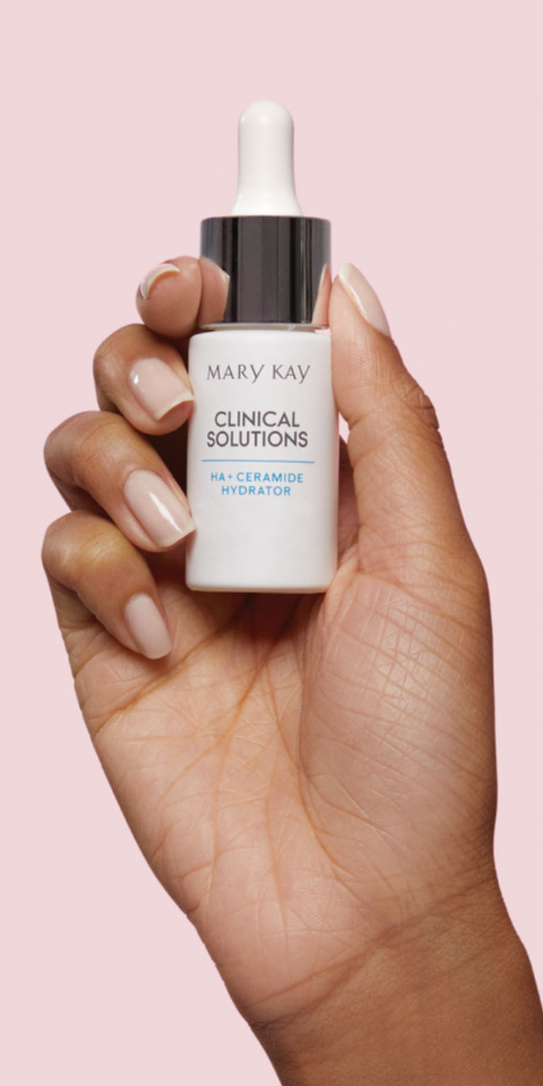 Modelo sosteniendo la botella del Hidratante HA + Ceramidas de Mary Kay&reg; Clinical Solutions sobre fondo rosa